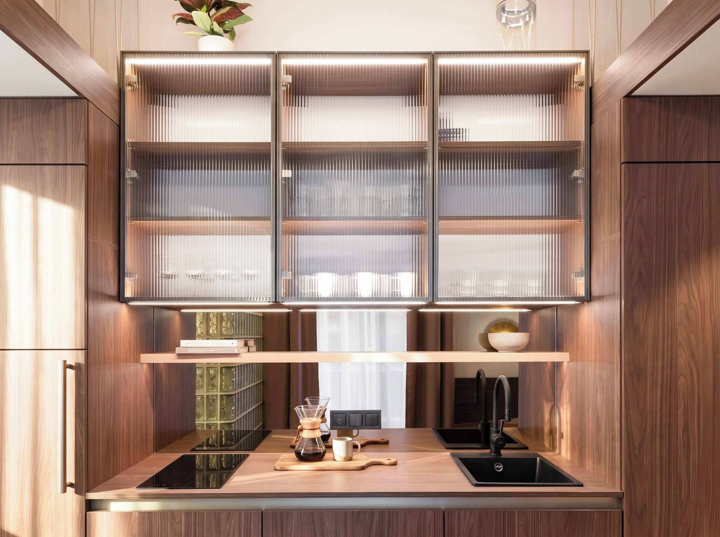 A modern kitchen with built-in cabinets, a coffee maker, and a sleek countertop.