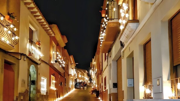 Un carrer estret amb edificis a ambdós costats, il·luminat per una llum càlida.