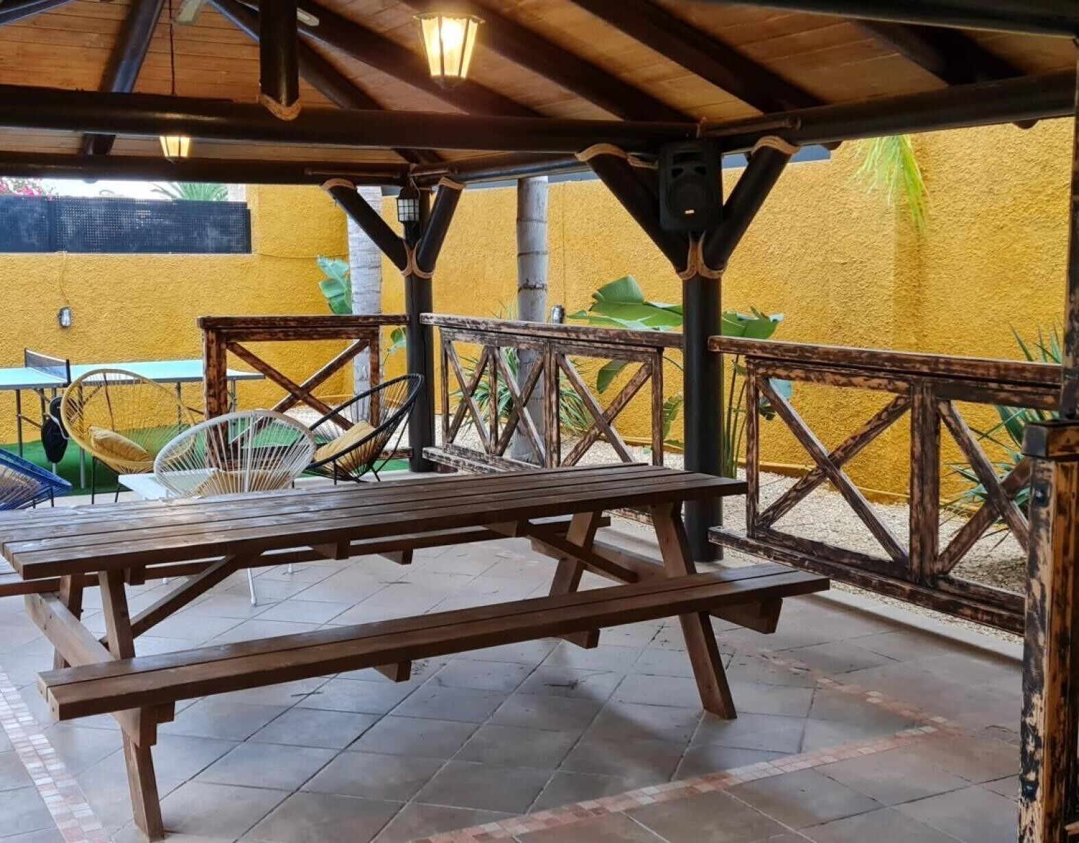 An outdoor patio with wooden benches and a fan.