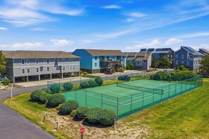 A residential area with a tennis court, houses, and a stop sign. - Surfsong | 750 ft to the beach | Community Pool (Corolla)