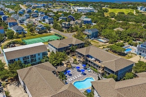 A residential area with multiple houses, a tennis court, and a swimming pool.