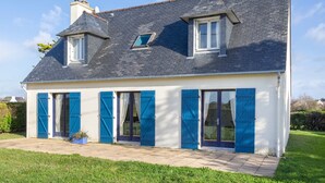 A two-story house with a sloped roof, large windows, and blue shutters. - Ty Mamm – 5 min from Beach – 3 Bedrooms – Sleeps 6 (Guilvinec)