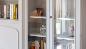 A bookshelf with books and decorative items. - Ty Mamm – 5 min from Beach – 3 Bedrooms – Sleeps 6 (Guilvinec)