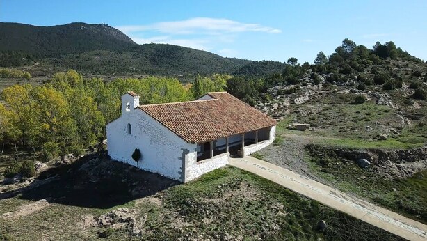 A white building with a tiled roof, surrounded by greenery and hills. - Country House 'La Cisterna II' (Pina de Montalgrao)