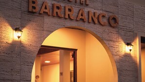 Een hotelingang met een stenen gevel en de naam 'Hotel Barranco' boven de ingang.