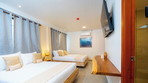 Een hotelkamer met twee bedden, een aan de muur bevestigde televisie en een houten plank.