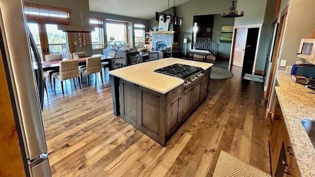 A spacious kitchen with a large island, wooden flooring, and modern appliances.