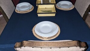 Una mesa con platos, un portavasos para servilletas y una caja pequeña.