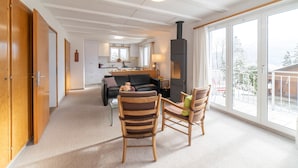 Una sala de estar acogedora con chimenea, un sofá y dos sillones.