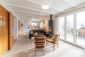 Una sala de estar acogedora con chimenea, un sofá y dos sillones.