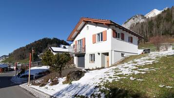 Ein zweistöckiges Haus mit rotem Dach, weißen Wänden und einem Balkon.