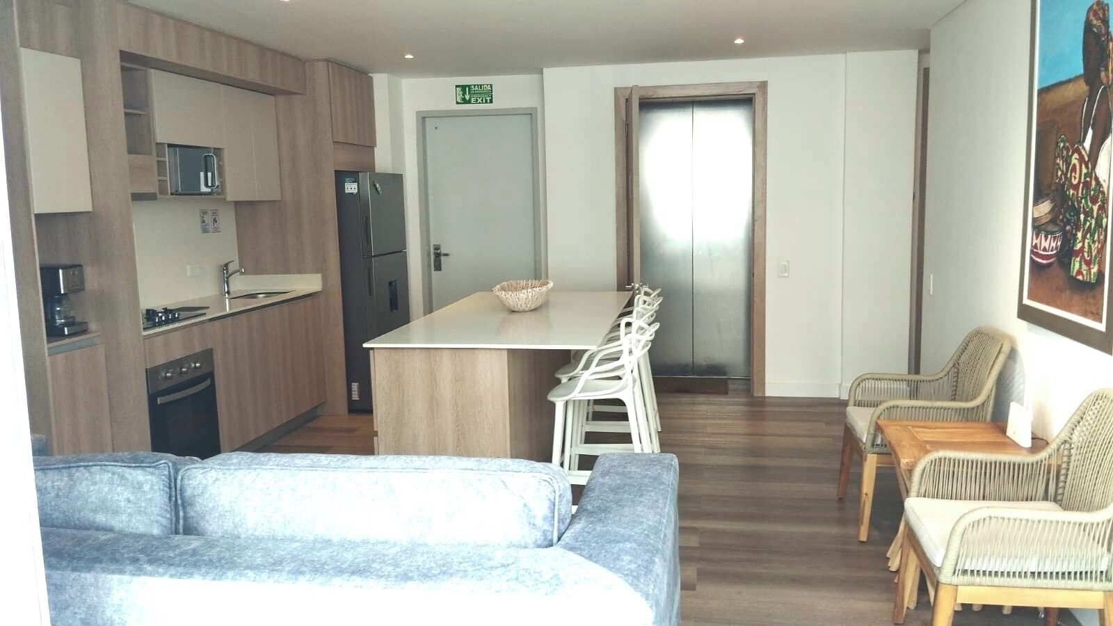 Een moderne keuken met een eethoek, een bank en rieten stoelen.