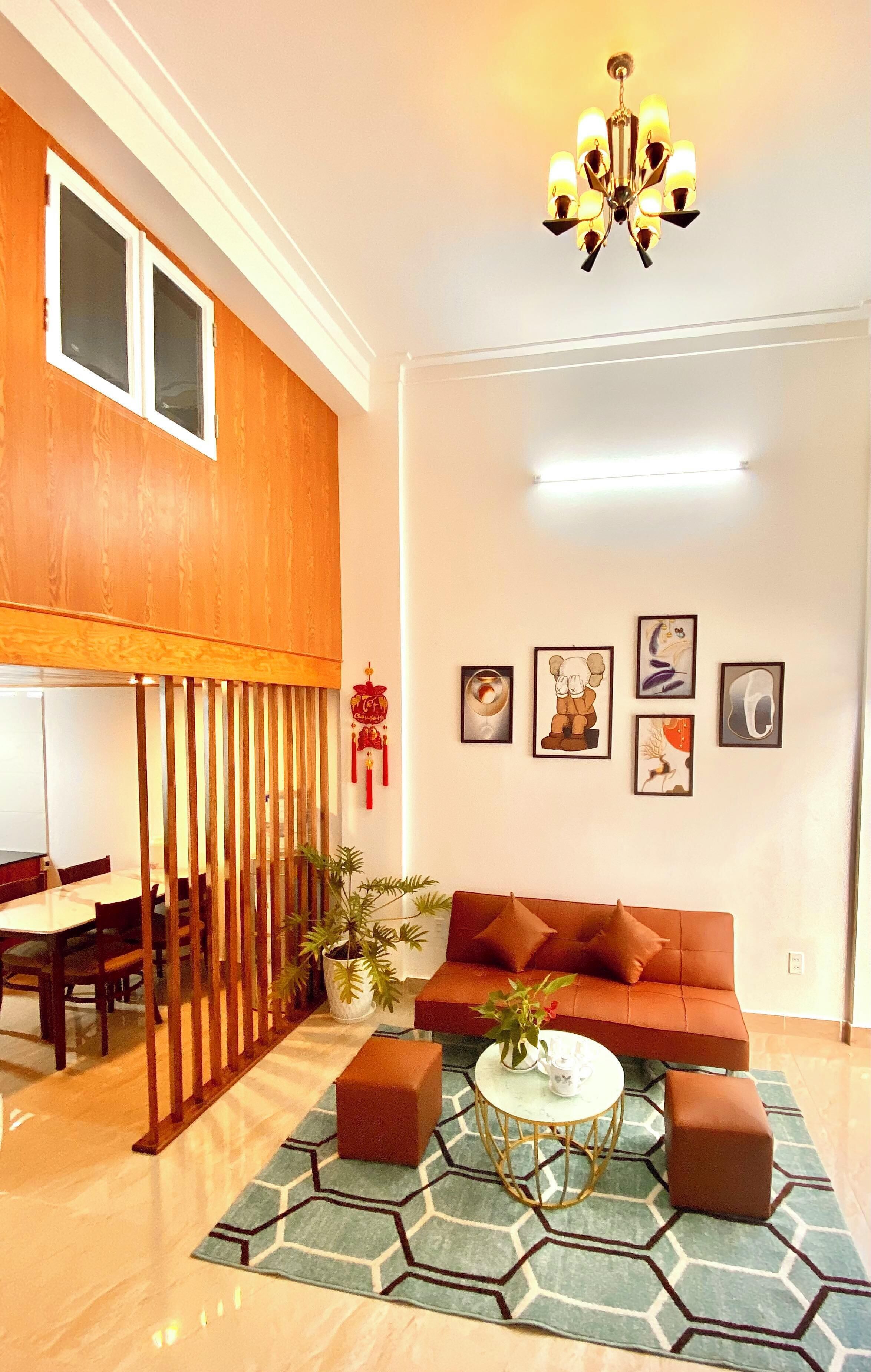 A modern living room with a wooden ceiling, a brown sofa, a round coffee table, and a decorative plant.