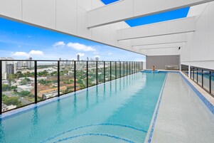 Una piscina al aire libre, sillones reclinables de piscina