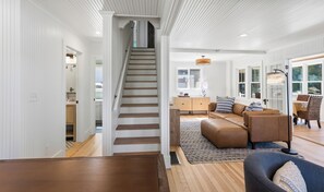 A spacious living area with a staircase, a sofa set, and a dining area. - Pier Michigan - seconds away from Lake Michigan and a public access (Grand Haven)