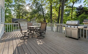 A wooden deck with a grill and outdoor furniture. - Captain's Corner | Walk to Beach, Relax by the Lake (Spring Lake)