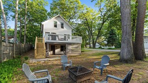 A two-story house with a balcony, surrounded by trees and a wooden fence. - Captain's Corner | Walk to Beach, Relax by the Lake (Spring Lake)