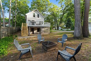 A two-story house with a balcony, surrounded by trees and a wooden fence. - Captain's Corner | Walk to Beach, Relax by the Lake (Spring Lake)