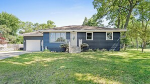 A single-story house with a front garage, a small porch with steps, and a well-maintained lawn. - Private pool, close to Lake Michigan Beaches (Muskegon)