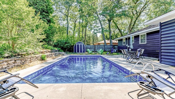 A swimming pool with lounge chairs and a small shed in a backyard. - Private pool, close to Lake Michigan Beaches (Muskegon)