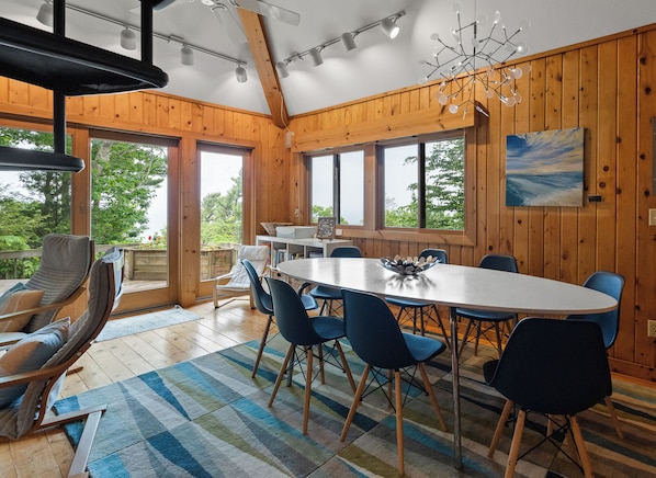 A dining area with a large table, blue chairs, and a view of the outdoors.