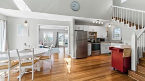 A spacious kitchen with a stainless steel refrigerator, wooden cabinets, and a red cart.