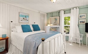 A bedroom with a bed, a nightstand, a chair, a dresser, a mirror, and artwork on the walls. - Rest-A-While: Spacious 4-Bedroom Retreat in Grand Haven (Grand Haven)