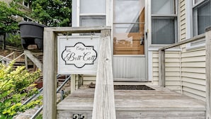 Un porche de madera con un cartel que dice "The Cottage #22 Bott Cott".