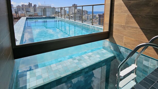 A rooftop swimming pool with a glass barrier, a view of the city skyline, and a clear sky. - Cozy Studio w Balcony & Pool in Carnival's Heart - SSA009 (Salvador - BA)