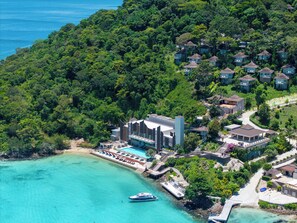 A resort with multiple bungalow-style accommodations surrounded by lush greenery, a swimming pool, and a dock with a boat. - Centara Villas Phi Phi Island (Ko Phi Phi)