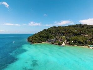 A coastal area with a clear view of the sea, a small island with dense greenery, and a few buildings. - Centara Villas Phi Phi Island (Ko Phi Phi)