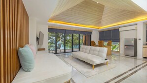 Una sala moderna con un sofá, una zona de comedor y una cocina.