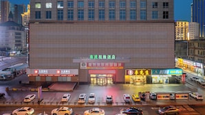 A multi-story building with a large entrance and several visible storefronts. - Dalian Youxi-ChengYuan Hotel (Dalian)