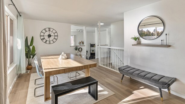 A modern living room with a wooden dining table, a bench, a large wall clock, and a mirror. - 4BD/3BA MTN Views/HTUB Close to Ski Resorts (Cottonwood Heights)