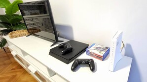 A gaming setup with a monitor, two controllers, and a PlayStation 4 console.