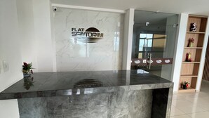 A reception desk with a marble top and a logo above it.