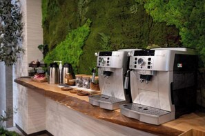 Una estación de café con dos máquinas de espresso, un molinillo y varios accesorios para preparar café.