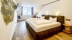 A bedroom with a bed, bedside tables, a desk, and a window. - Comfortable and versatile room -perfect for relaxation, work and exchange (Winterberg)