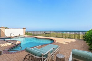 An outdoor swimming pool with lounge chairs and a view of the ocean. - Prestigious Private Home with Oceanfront Pool! (South Padre Island)