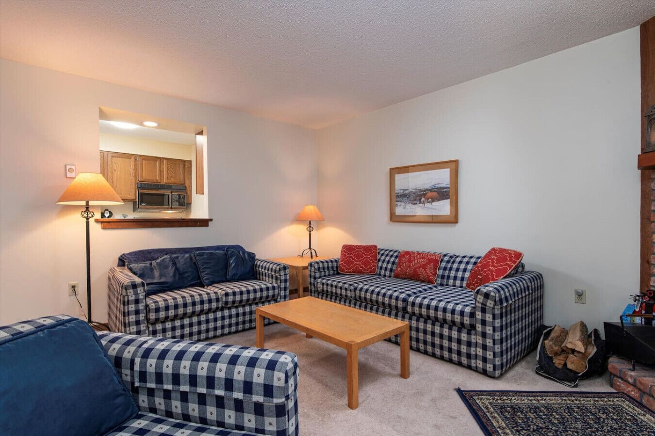 A cozy living room with a sofa set, a coffee table, and a fireplace.
