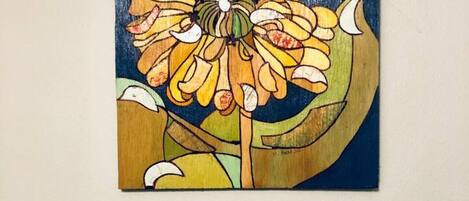 Dos cuadros de flores, uno más grande y otro más pequeño, sobre un fondo liso.