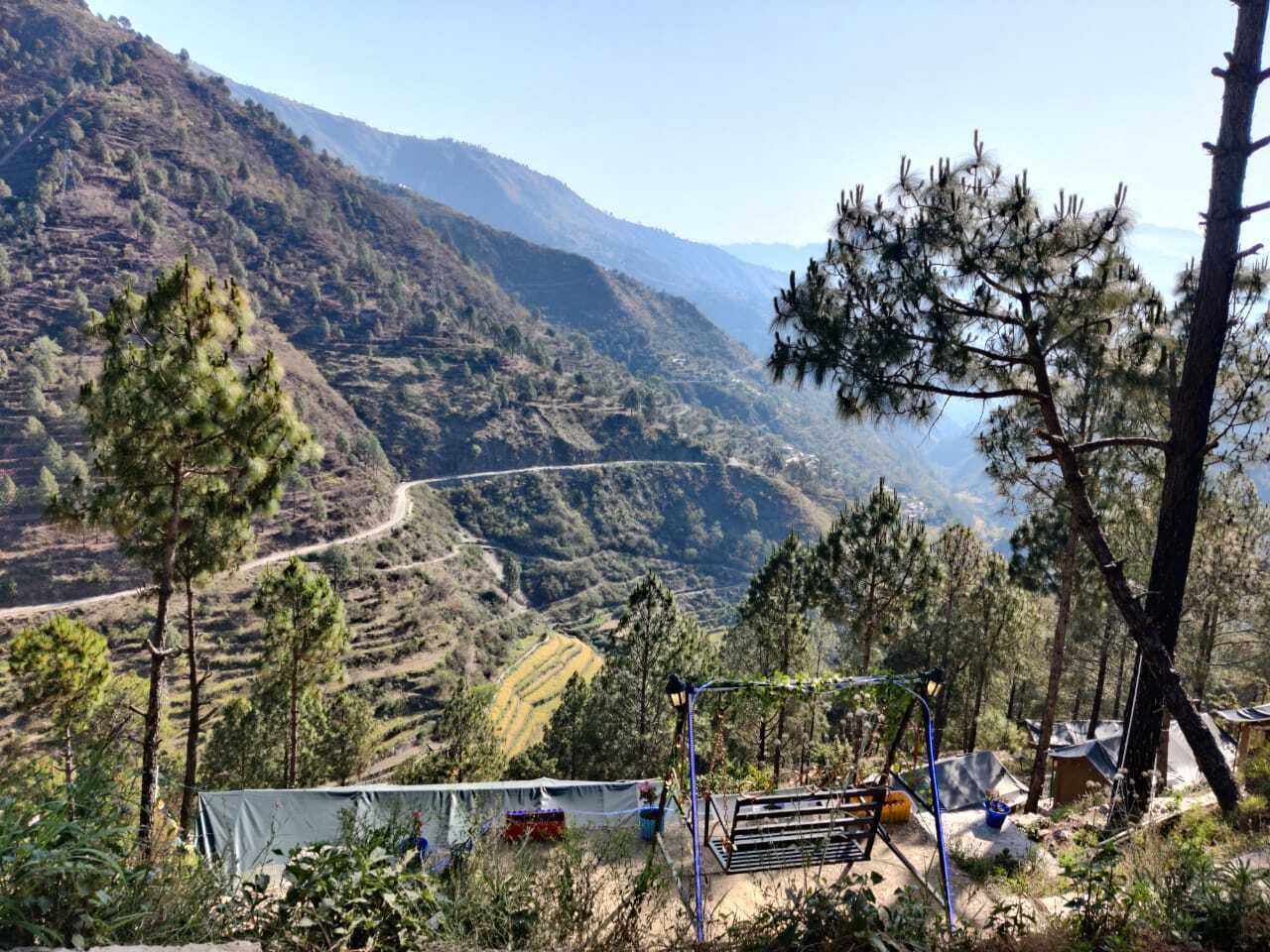 A mountainous landscape with a clear view of terraced fields and a road winding through the valley.