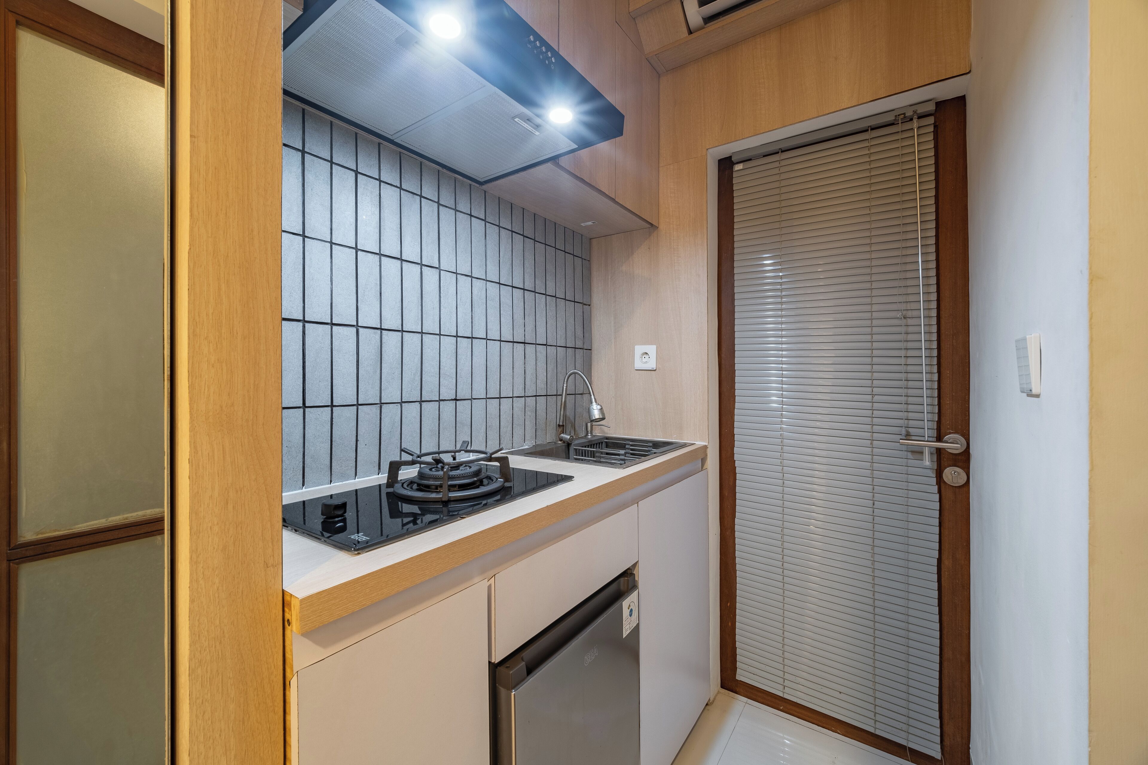 A compact kitchen with a built-in stove, a sink, and a dishwasher.