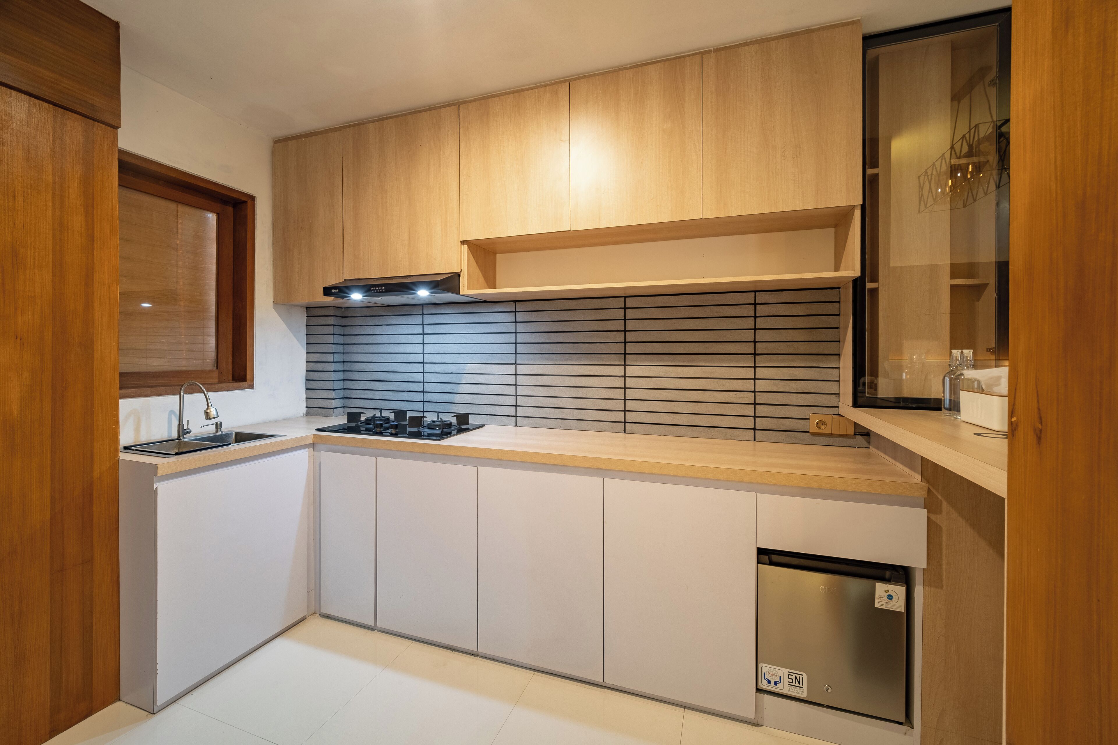 A modern kitchen with wooden cabinets, a built-in stove, and a dishwasher.