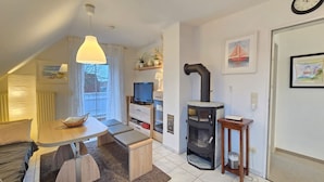 Een moderne woonkamer met een eethoek, een open haard en een televisie.