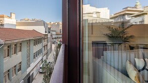 A view from a window overlooking a city street with buildings and a clear sky. - GuestReady - Modern ambience in Porto (Porto)