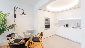 A modern kitchen with white cabinets, a built-in oven, and a sink. - GuestReady - Modern ambience in Porto (Porto)