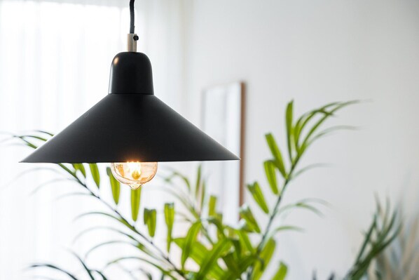 A black pendant light with a visible bulb hanging from a ceiling.