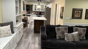 A modern kitchen with white cabinetry, a central island, and a dining area. - Lovely 4-bedroom house in charming Irving with AC, WiFi - Coppell Schools. (Irving)