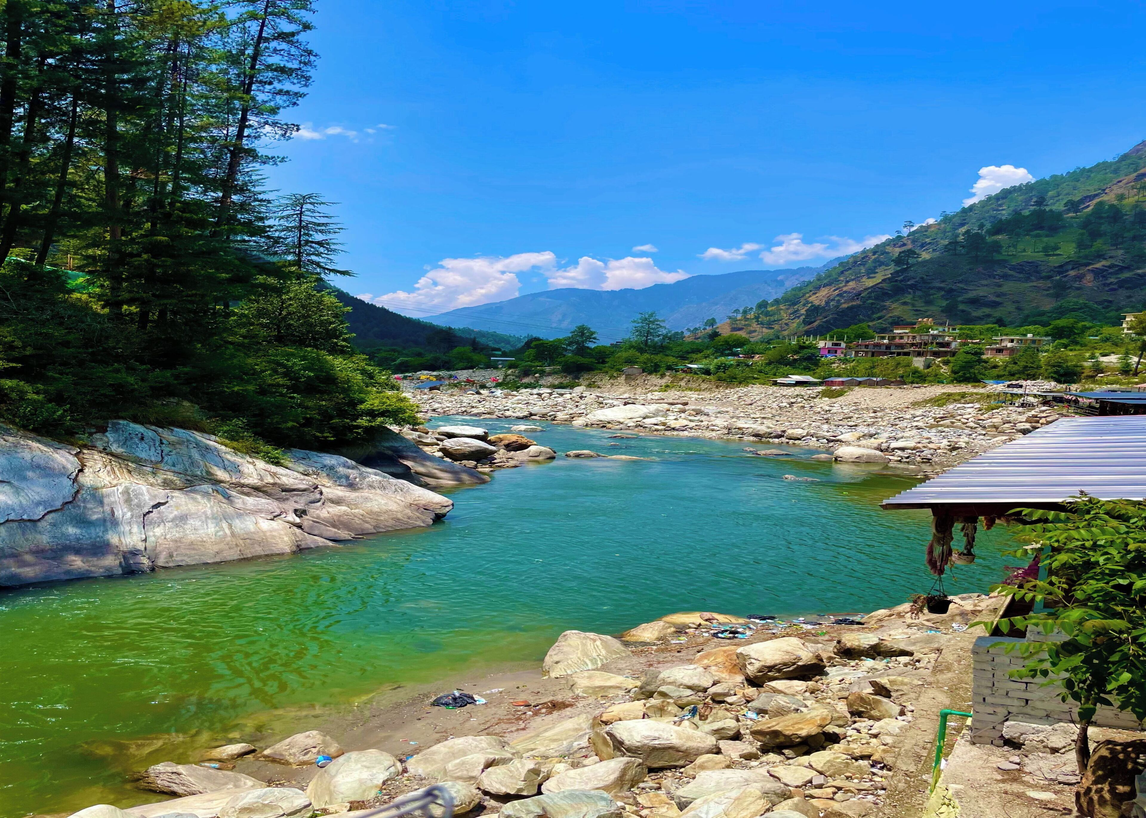 A river flowing through a rocky landscape with a small building on the right.